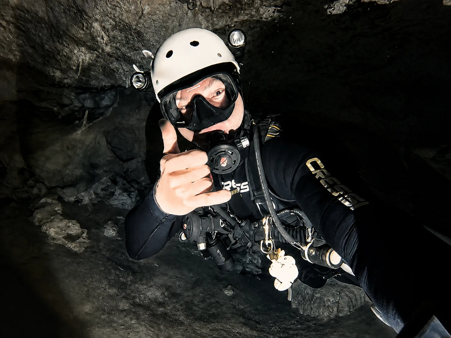 Instrutor da Atlantes equipado para mergulho em caverna, com capacete e iluminação redundante