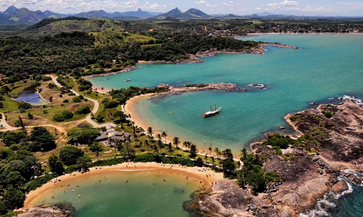 Praia tranquila com água cristalina e coqueiros em Guarapari